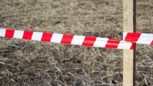afzetlint aan paal bij grasveld