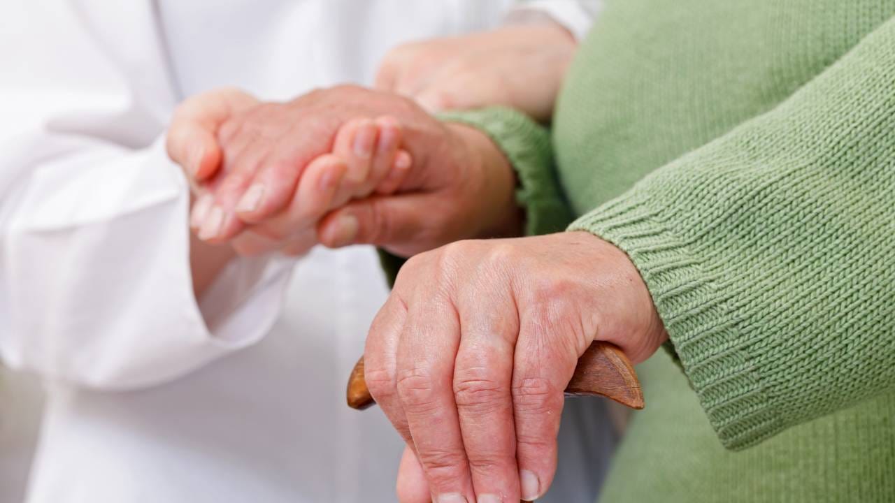 ondersteunende hand bij bejaarde vrouwenhand veiligheid bij het aanbieden van dagbesteding