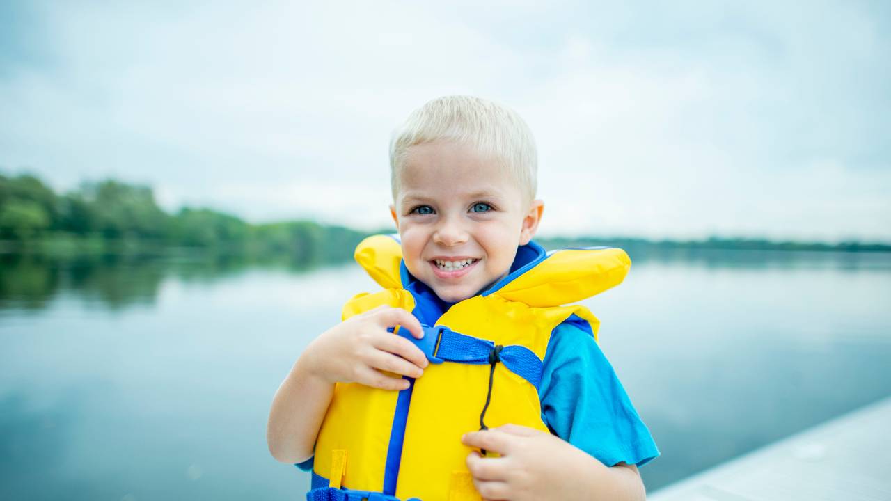 blond kindje met een reddingsvest aan