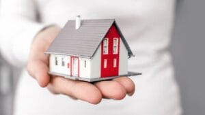 open vrouwelijke hand houdt mini huis vast wie mag een open jeugdzorg groep starten